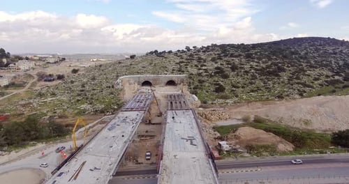 Aerial footage of a large scale highway construction project with tunnels and bridges