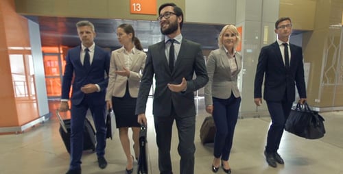 Confident Business Team Walking Through Modern Airport