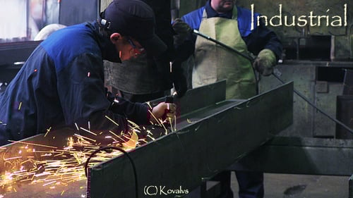 Metalworker Grinding Metal Beam with Sparks in Factory