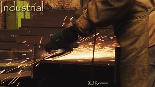 Worker Cutting a Metal Beam in an Industrial Shop