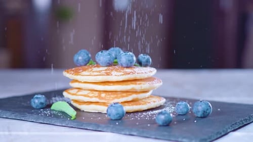 Pastry Powder Falls in Slow Motion on Pancakes with Blueberries
