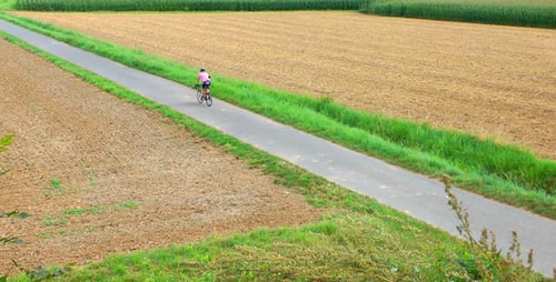 Mann mit Fahrrad im Feld 1