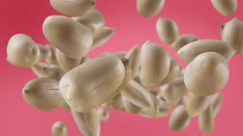 Peanuts Falling Against a Pink Background