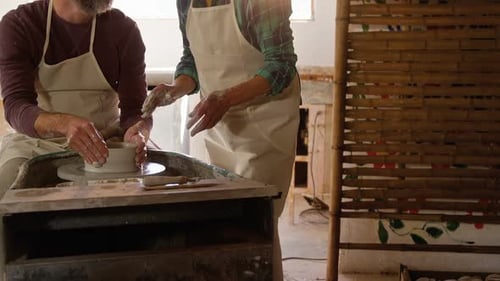 Un potier aide une potière
