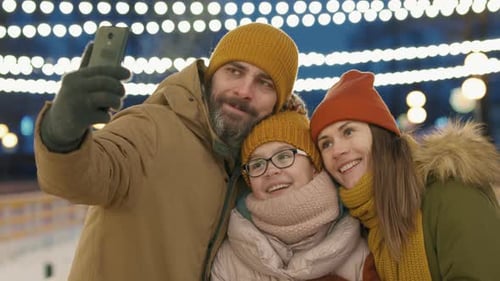 Smiling Family Takes Selfie at Night