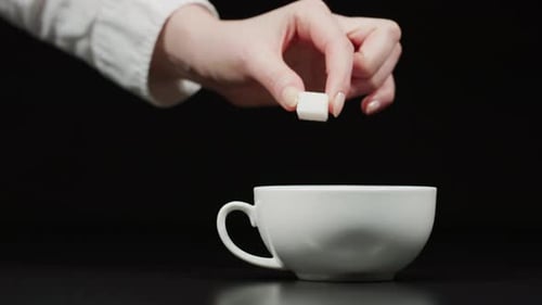 Adding sugar cube to the tea