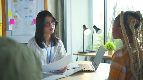 Frau beim Vorstellungsgespräch und drei Startup-Gründermitglieder