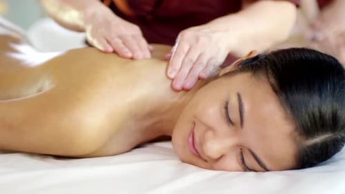 Junge Frau aus dem Nahen Osten mit Rückenmassage
