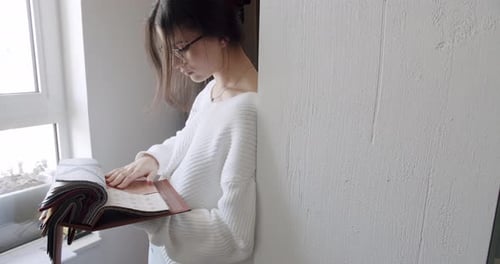 Young Women in the Store Who Choose Fabrics From the Color Palette in Showroom