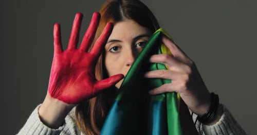 Niña se esconde en el miedo y levanta su mano roja como señal de alto