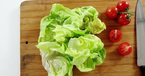 Lettuce, Tomatoes, and Knife on Cutting Board