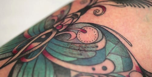 Close Up Tattoo Artist Applying Green Ink