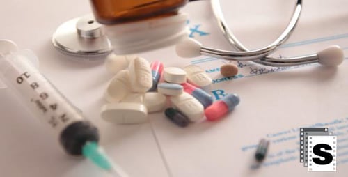 Pills Spill Out Next to Medical Equipment