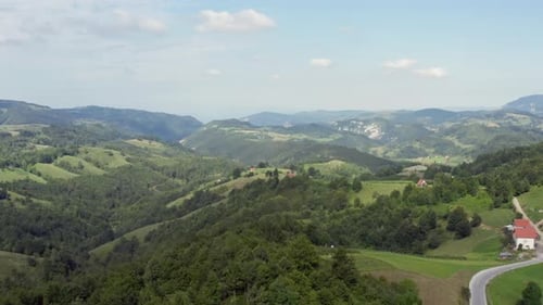 Vol de Drone dans les montagnes Petite maison entourée de champs