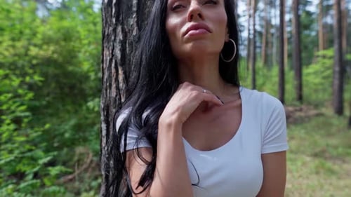 Woman Standing Next To a Tree in a Forest