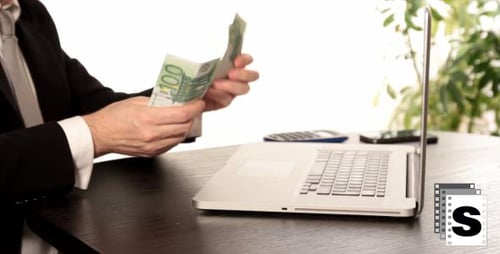 Man Typing on Laptop and Counting Money