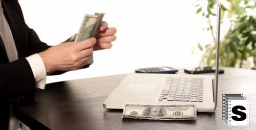 Typing and Counting Money on Laptop