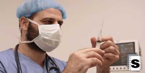 Doctor Holding Syringe Preparing for Injection