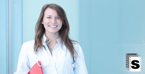 Smiling Doctor with Stethoscope Poses in Hospital Setting