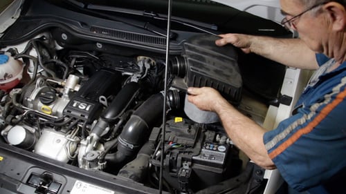 Kfz-Reparatur-Mechaniker montiert Kfz-Luftfilter