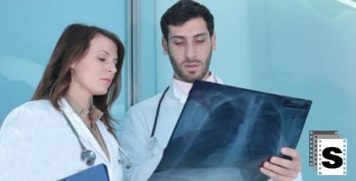 Doctors Reviewing X-ray in Hospital Corridor