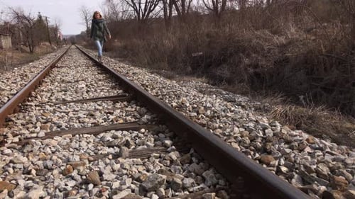 Tägliche Szene mit Frau, die auf Schienen geht 4K 2160p 30ffps UltraHD-Aufnahmen - Weiblich auf verlassener Eisenbahn