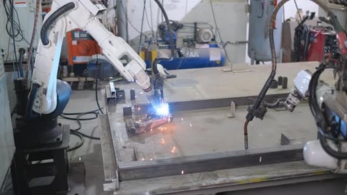 A nova máquina robótica de braço está soldando o metal, enquanto o modelo robótico antigo não se move