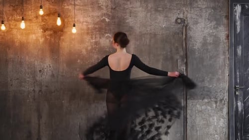 Woman Dancing Gracefully in Black Dress
