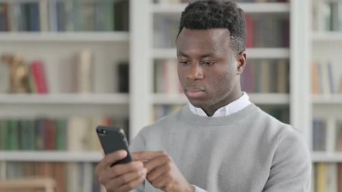 Young Man Using Smartphone Indoors Close Up