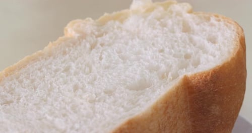 Hand Tearing Apart a Slice of Fresh Bread