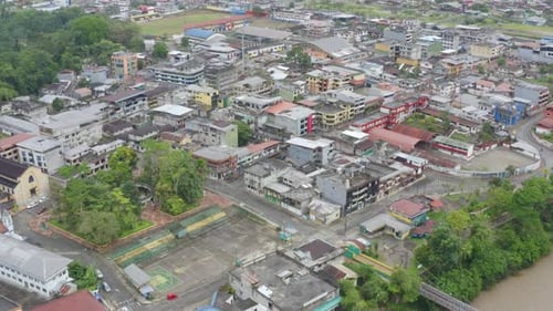 Vista aérea de uma grande cidade no Equador, mostrando um campo de futebol desgastado