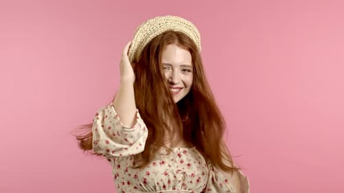 Beautiful Woman with Beautiful Hair Dancing on Pink Studio Background. Cute Girls Portrait. Party