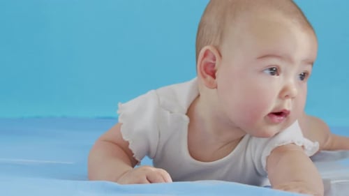 Beautiful Smiling Baby A Gorgeous Little Baby Lies on the Bed and Smiles at the Camera with a Nice