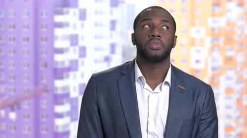 Man smiles against a building background