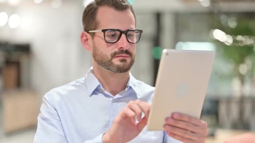 Man Using Tablet Device in Modern Office Environment