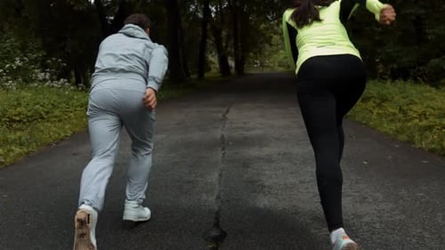 Fitness-Paar bereit für das Rennen auf einem hölzernen Gehweg auf einer Startlinie im Freien Park