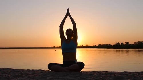 Meditation Near the Sea and Doing Yoga on a Beach at Sunset