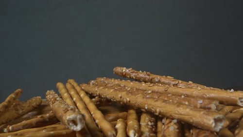 Delicious Pretzel Sticks with Seeds on Wooden Table