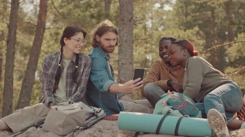 Multiethnic Friends Watching Memes on Smartphone in Forest