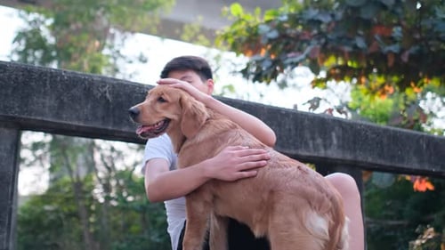 Asian young man hug his dog and sit on bridge and sideroad with happy emotion
