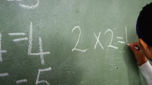 Girl Writes Math Equation on Chalkboard at School
