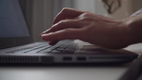Hands Typing on Laptop Keyboard at Home