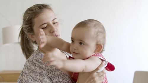 Medium Shot of Smiling Little Baby Sitting on Mothers Hands