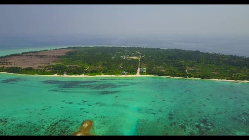 Aerial drone shot travel of tranquil coastline beach lifestyle by blue green sea and clean sand back