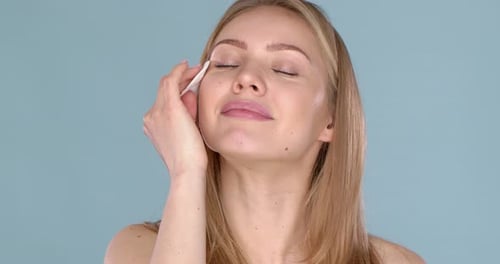 Skin Care Concept. Woman Removing Face Makeup with Cotton Swab Pad Facial Closeup of Beautiful Model