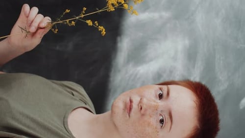 Young Adult Holds Delicate Yellow Flower, Close Up