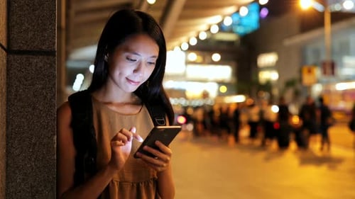 Woman using smart phone in Hong Kong at night
