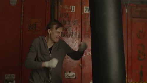 Young Man Punches Heavy Bag