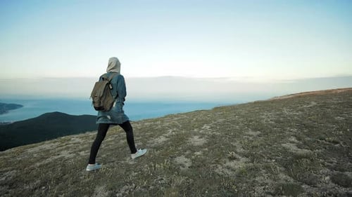 Woman Hiker Walking on Mountain Terrain Wearing Backpack