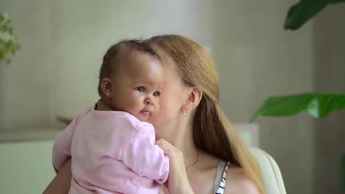 Loving Mother Holds Infant Close and Kisses